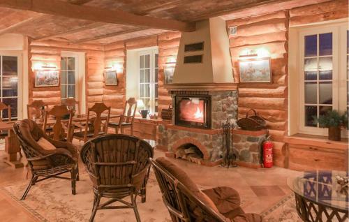 a living room with a fireplace in a log cabin at 5 Bedroom Pet Friendly Home In Srokowo in Srokowo