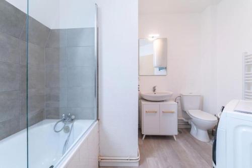 une salle de bain avec une baignoire, un lavabo et des toilettes dans l'établissement Franklin City, à Mulhouse