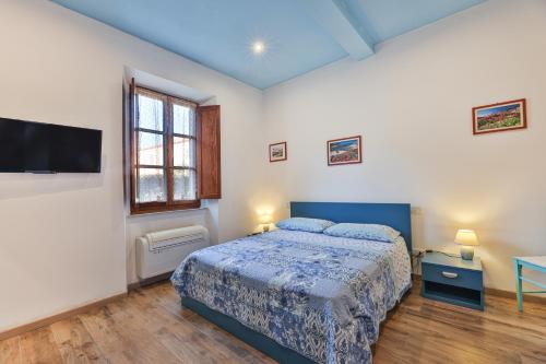 a bedroom with a bed and a flat screen tv at Villa Lulu al Cavo - Elba Affitti in Cavo