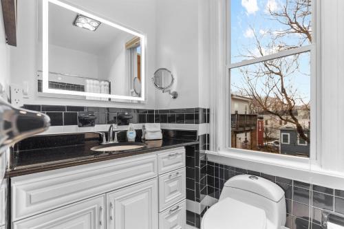 a bathroom with a toilet and a sink and a window at Spacious and Central DC 3-BR Getaway Close to It All in Washington, D.C.