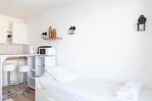 Cette chambre blanche dispose d'un lit et d'une cuisine. dans l'établissement Charming studio in Saint-Denis, à Saint-Denis