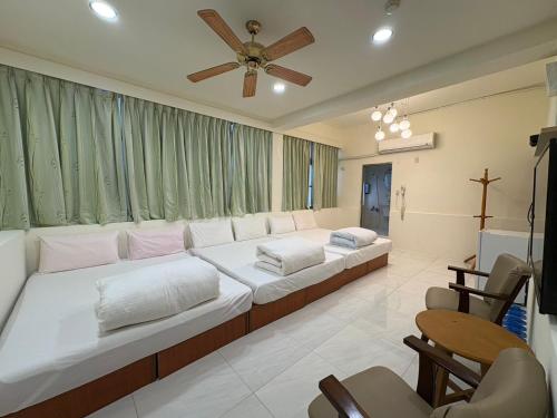 a bedroom with two beds and a ceiling fan at Wayu House in Dawu
