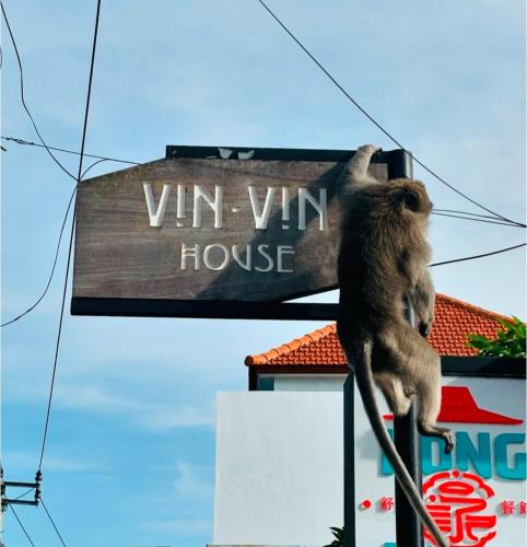 a monkey is sitting on top of a sign at Vin vin in Ubud