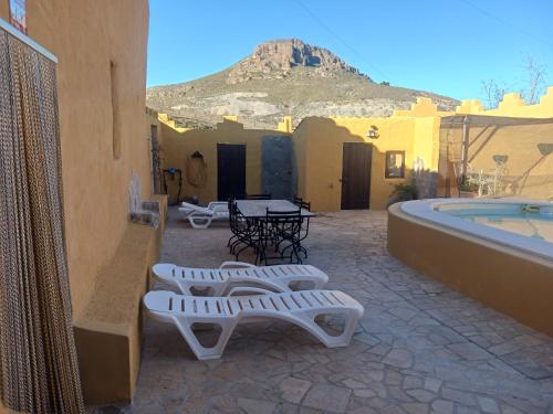 a patio with a table and chairs next to a pool at Casa rural los Cerezos in Albox
