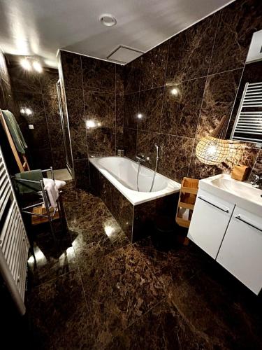 a bathroom with a tub and a sink at Tempor'area Apartment in Antwerp