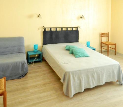 a bedroom with a bed with a green pillow on it at Maison familiale spacieuse à Le Verdon-sur-Mer avec jardin 120 m² in Le Verdon-sur-Mer