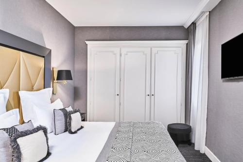 a bedroom with a large white bed with pillows at Hôtel Barrière Le Majestic Cannes in Cannes