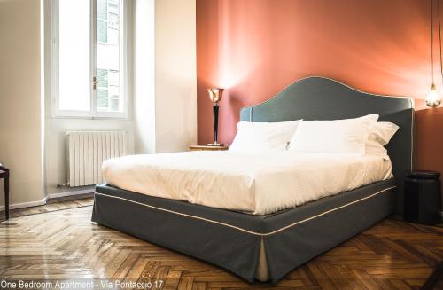 sypialnia z dużym łóżkiem z zielonym zagłówkiem w obiekcie Brera Apartments w Mediolanie