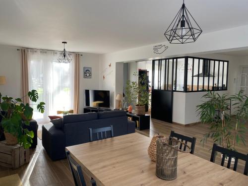 un salon avec un canapé et une table dans l'établissement Gite l Auvetia 150 circuit 24 h, à Arnage