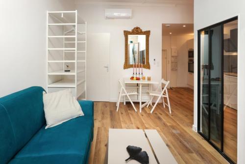 un salon avec un canapé bleu et une table dans l'établissement La Demeure du Chevalier d'Argent- parking gratuit, à Carcassonne