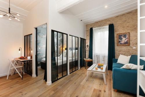 un salon avec un canapé bleu et une chambre dans l'établissement La Demeure du Chevalier d'Argent- parking gratuit, à Carcassonne