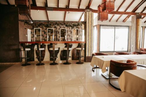 a dining room with tables and chairs and a window at Hotel l'ATLANTYS in Yopougon-Attié