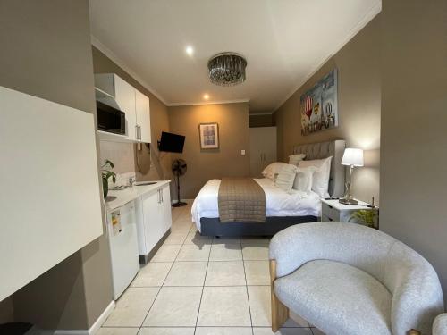a hotel room with a bed and two chairs at DOMIN LUXURY SUITES in Cape Town