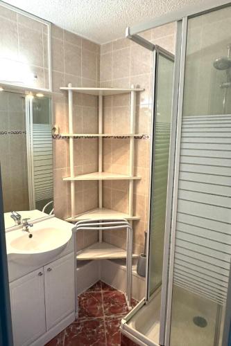 une salle de bain avec un lavabo et une douche dans l'établissement coquet appartement 1 chambre avec parking bord de plage, à Sète