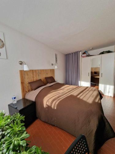 une chambre avec un grand lit dans une pièce dans l'établissement La Chrysalide, au Cap d'Agde