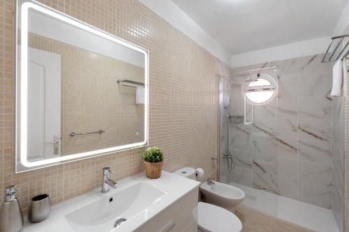 a bathroom with a sink and a toilet and a mirror at Apartamento Rincon Tropical in Candelaria
