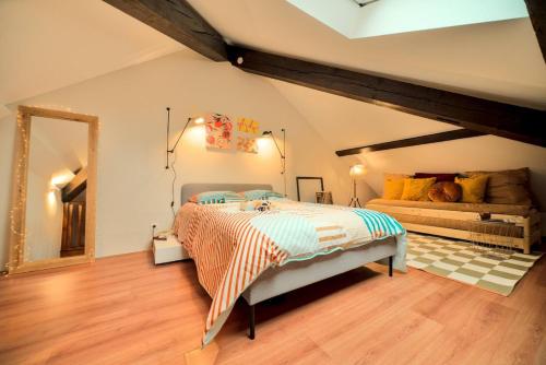 - une chambre avec un lit dans une pièce avec un canapé dans l'établissement Superbe appartement contemporain Mulhouse Centre, à Mulhouse
