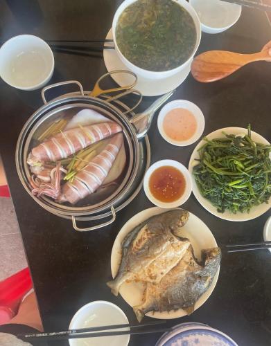 a table with different types of food on it at Homestay Phú Thường Beach in Phước Ðổng (1)