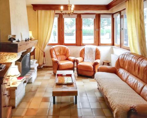 a living room with leather furniture and a fireplace at Maison avec jardin à Vierzon in Vierzon