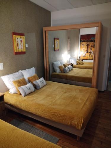 - 2 lits dans une chambre d'hôtel avec un grand miroir dans l'établissement Gîte La Rose des Alpes à Serres, 3 chambres, capacité 4 à 8 personnes, Cuisine, Terrasse, Parking et Garage, à Serres