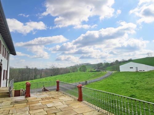 a balcony with a fence and a green field at Cosy house with jacuzzi in Zugarramurdi in Zugarramurdi