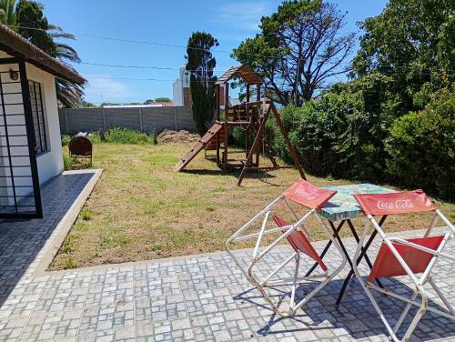 two chairs and a table and a playground at La Casita in Mar del Plata