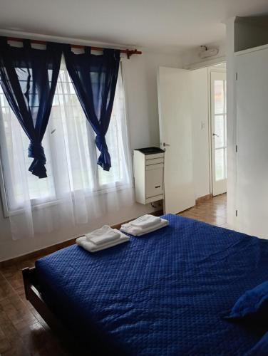 a bedroom with a blue bed with two towels on it at La Casita in Mar del Plata