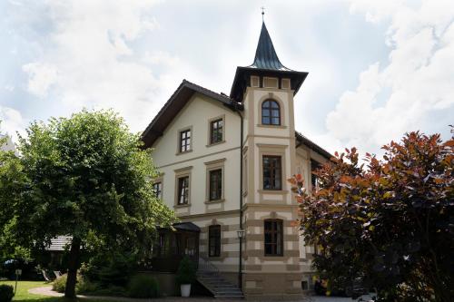 a church with a steeple on top of a building at Villa Fantasia Budget Boutique Hotel in Füssen