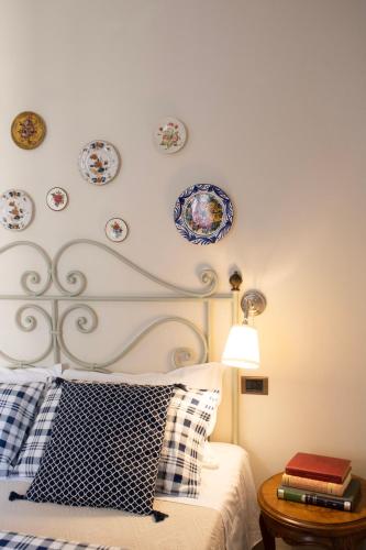a bedroom with a bed with plates on the wall at Boutique Hotel Fox's Inn in San Giustino Valdarno
