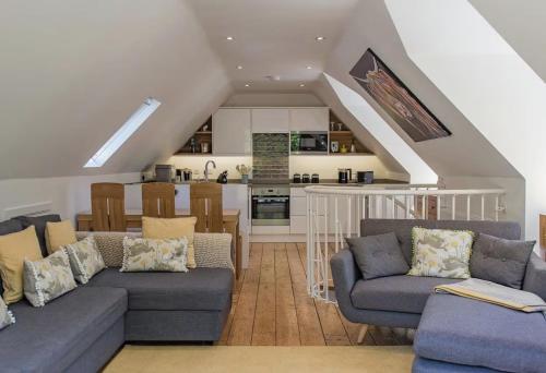 a living room with two couches and a kitchen at The Manor Coach House in Canterbury