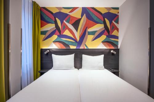 a bed in a room with a painting behind it at Thon Hotel Rotterdam City Centre in Rotterdam