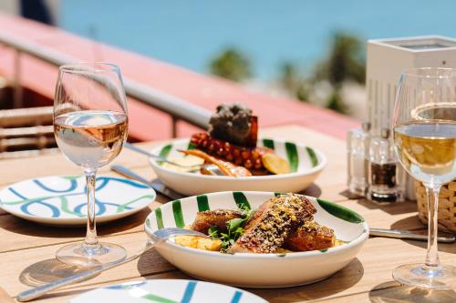 a table with plates of food and glasses of wine at AC Hotel by Marriott Nice in Nice