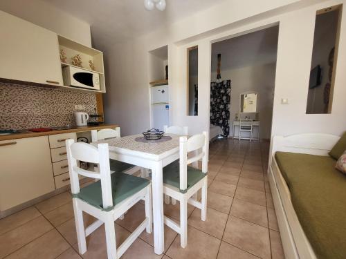 a kitchen and dining room with a white table and chairs at Ilaira Beach Apartments in Chrani