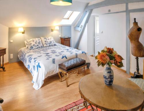 a bedroom with a bed and a table with a vase at Maison charmante proche de Montlognon avec jardin clôturé. in Montlognon