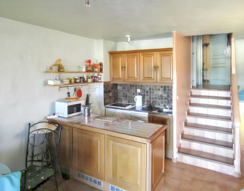 une cuisine avec des armoires en bois et un comptoir dans l'établissement Maison accueillante à Calcatoggio avec jardin clôturé., à Calcatoggio