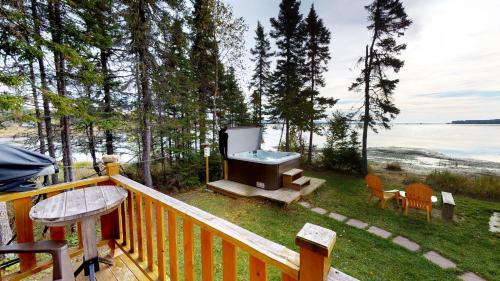 a balcony with a grill and a table and chairs at Chalets du bout du monde in Gaspé