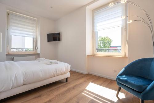 une chambre avec un lit et une chaise bleue dans l'établissement Beautiful apartment 2 pers Gare Mulhouse, à Mulhouse