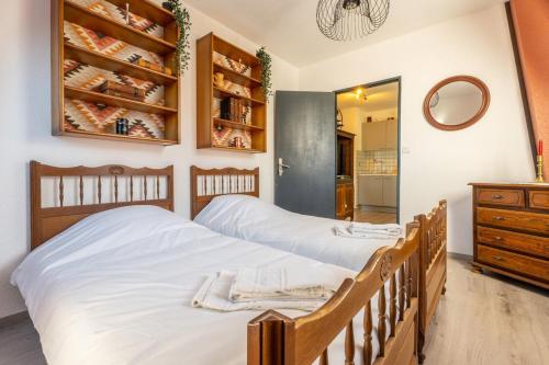 deux lits jumeaux dans une chambre avec un miroir dans l'établissement Logement Traditionnel au Style Alsacien Central, à Mulhouse