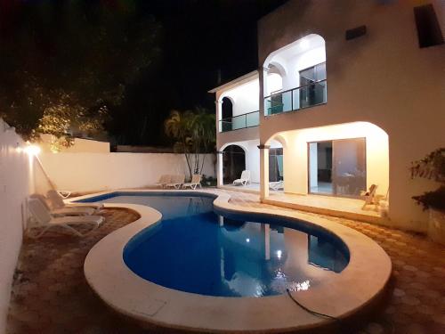 a swimming pool in front of a house at night at Casa los fundadores 24 7 Security Private Pool Service Included in Playa del Carmen