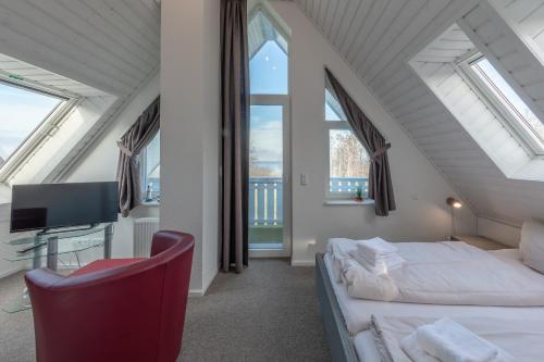 a attic bedroom with two beds and a chair at Kapitänsdeck 534 in Rechlin