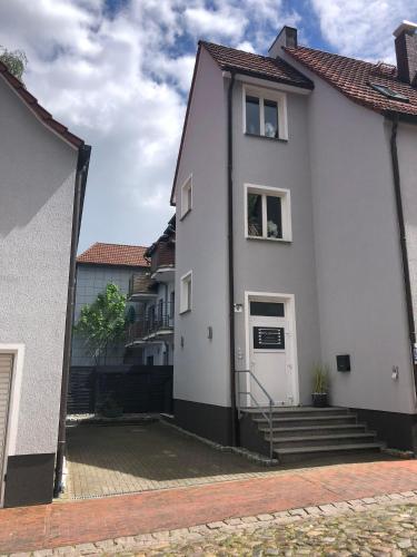 a white house with a white door and stairs at Müritz Apartments in Waren