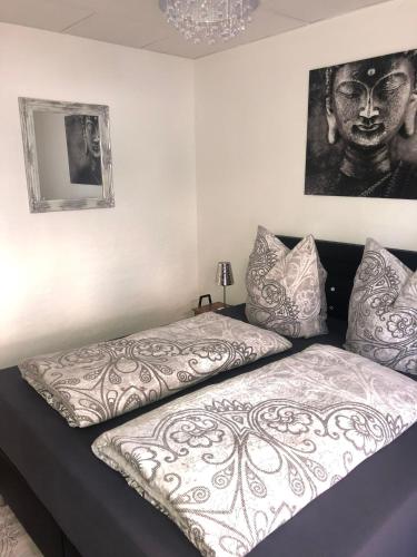 a bed in a room with a black and white comforter at Müritz Apartments in Waren