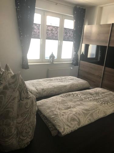 a bedroom with two beds and two windows at Müritz Apartments in Waren