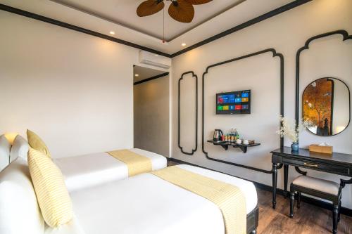 a bedroom with a bed and a desk and a mirror at Luang Prabang Vang Luang Hotel in Luang Prabang