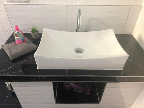 a white sink on a counter in a bathroom at Müritz Apartments in Waren