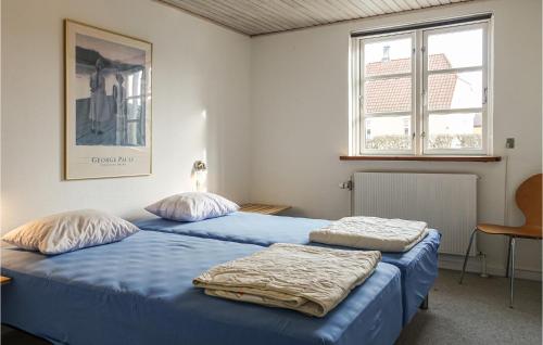 two beds in a room with blue sheets at Lovely Home In Nexø With Wifi in Neksø