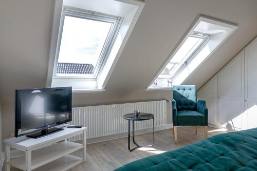 ein Wohnzimmer mit Fernseher und Sessel in der Unterkunft Strand Brise in Westerland