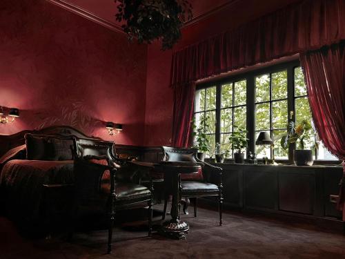 a bedroom with a bed and a table and a window at Hotel Villa Achenbach in Düsseldorf