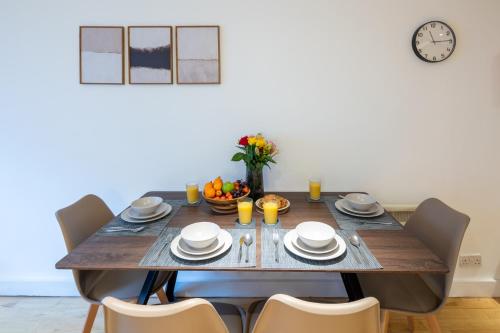 a dining room table with chairs and a clock on the wall at Central Flat-2Bedrooms-2Bath-By FabAccommodation in Bristol