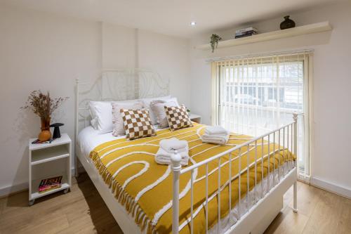 a bedroom with a bed with yellow and white sheets at Central Flat-2Bedrooms-2Bath-By FabAccommodation in Bristol